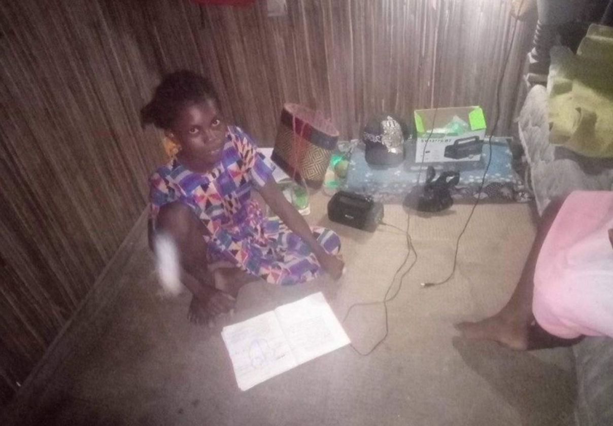 Christine fait ses devoirs avec de la lumière issue du kit solaire.